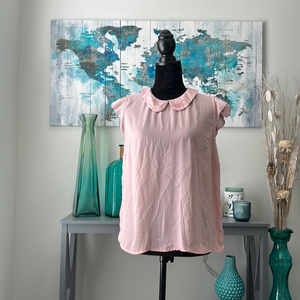 Pink shirt with caped sleeves and a buttoning back with collar detail. POPSUGAR.
